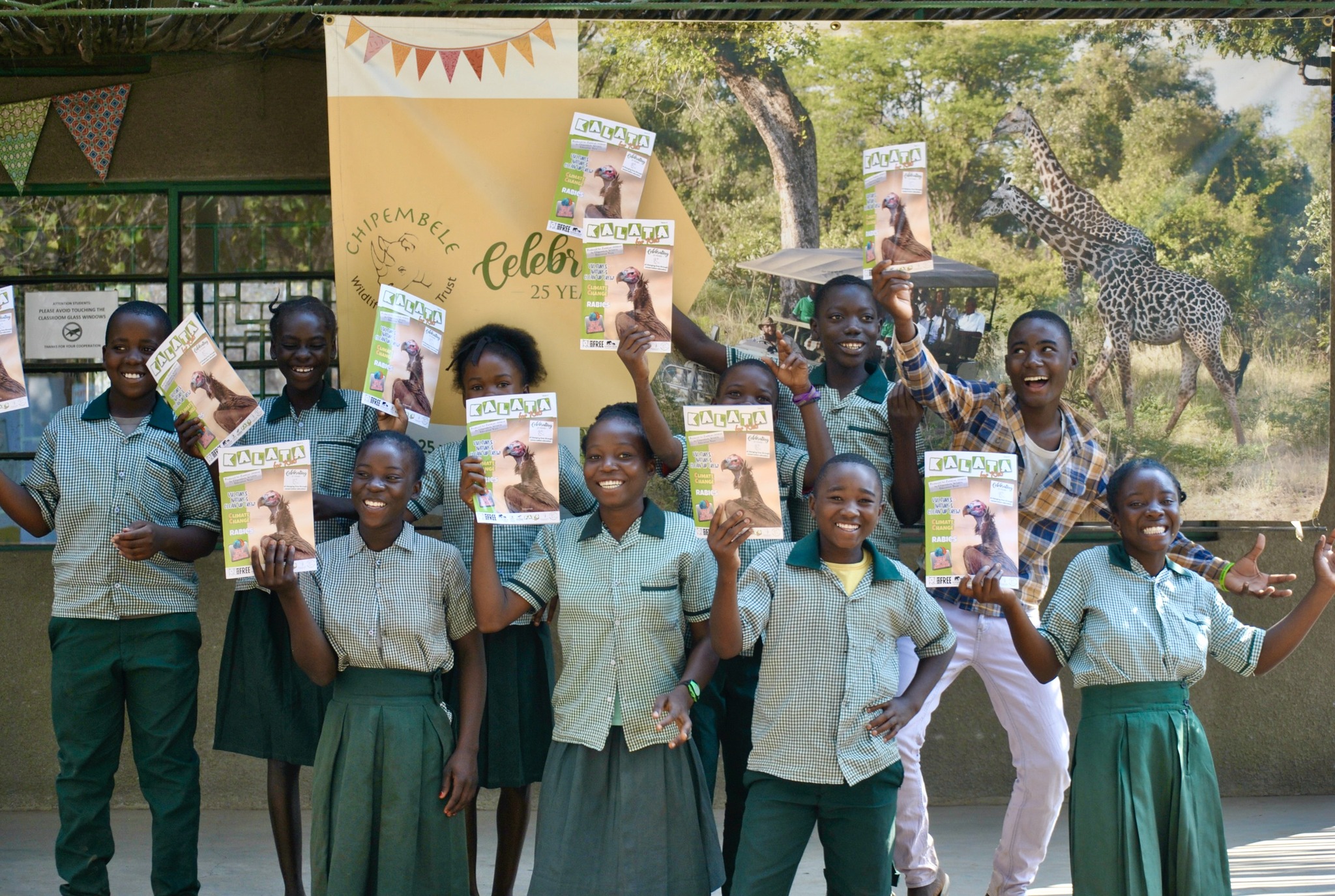Bildquelle Chipembele Wildlife Education Trust, 
Schüler und Schülerinnen von Chipembele Wildlife Education Trust halten die Geierausgabe des Jugendmagazins Kalata in die Kamera.
